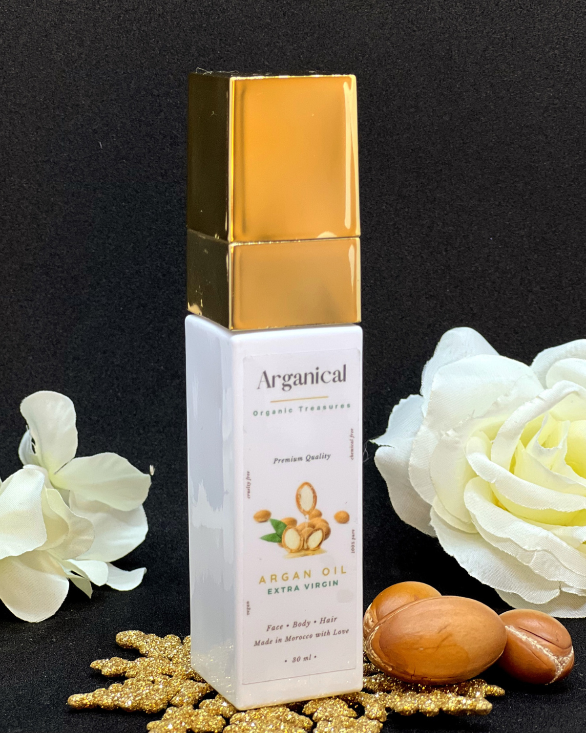 Arganical argan oil 30ml bottle with gold cap on a dark background with argan nuts.