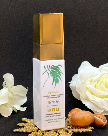 Back of Arganical argan oil 30ml bottle with gold cap on a dark background with argan nuts