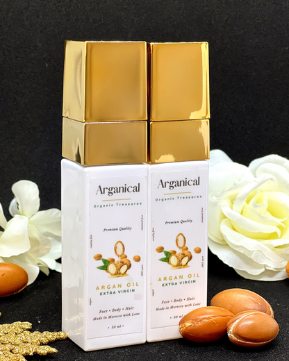 Arganical duo set argan oil 2* 30ml bottleswith gold cap on a dark background with argan nuts.